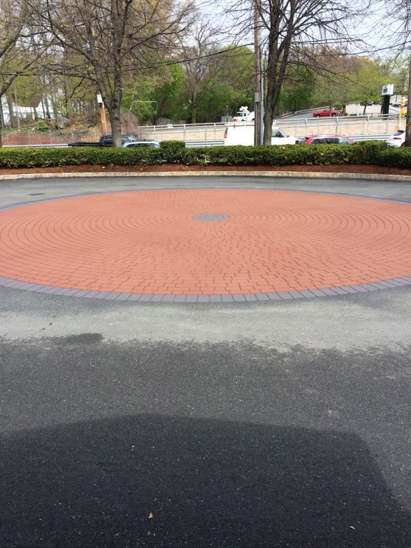 A brick circle in the middle of a parking lot
