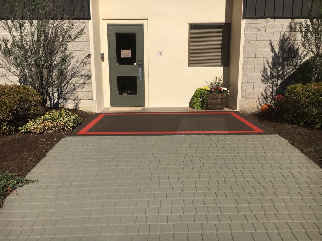 A brick walkway leading to a building with a door