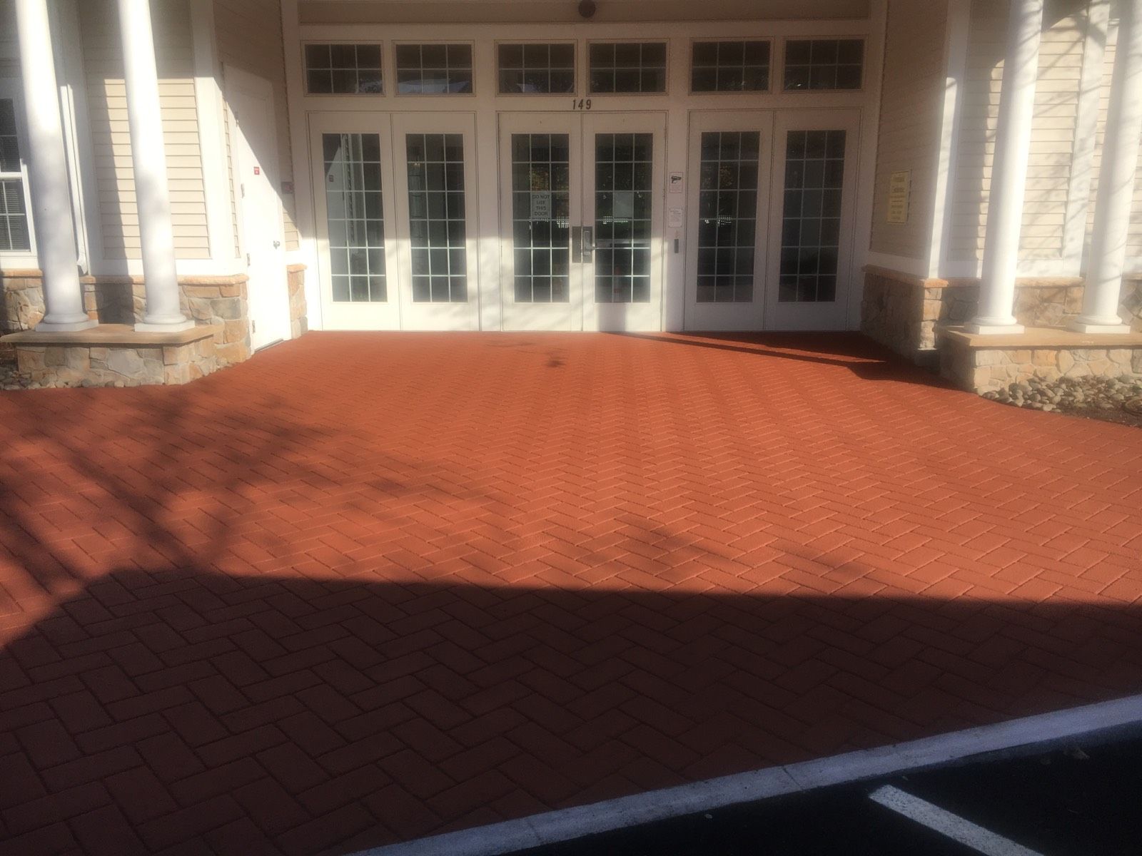 A brick walkway leading to a building with a white door