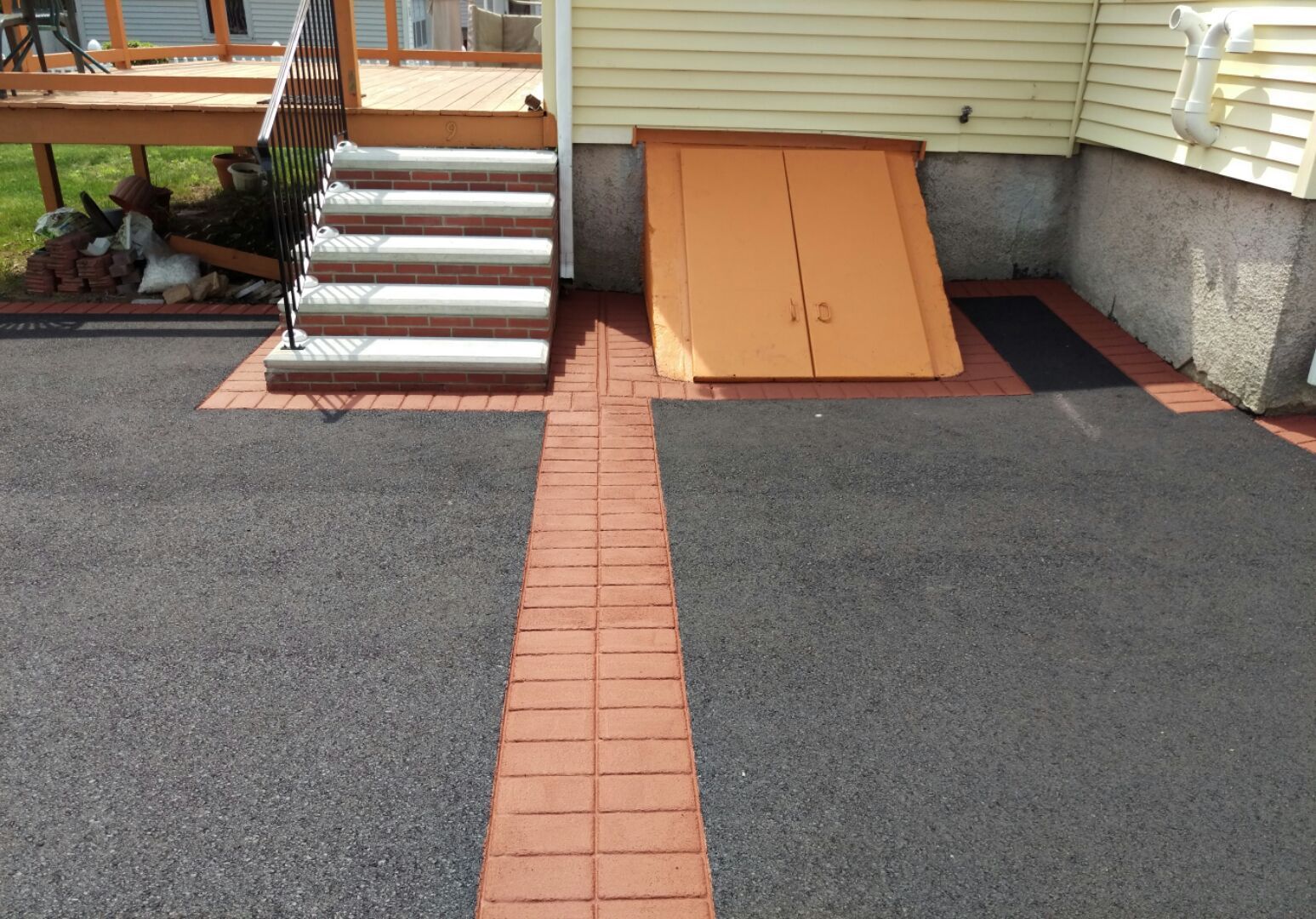 A driveway with a ramp and stairs in front of a house