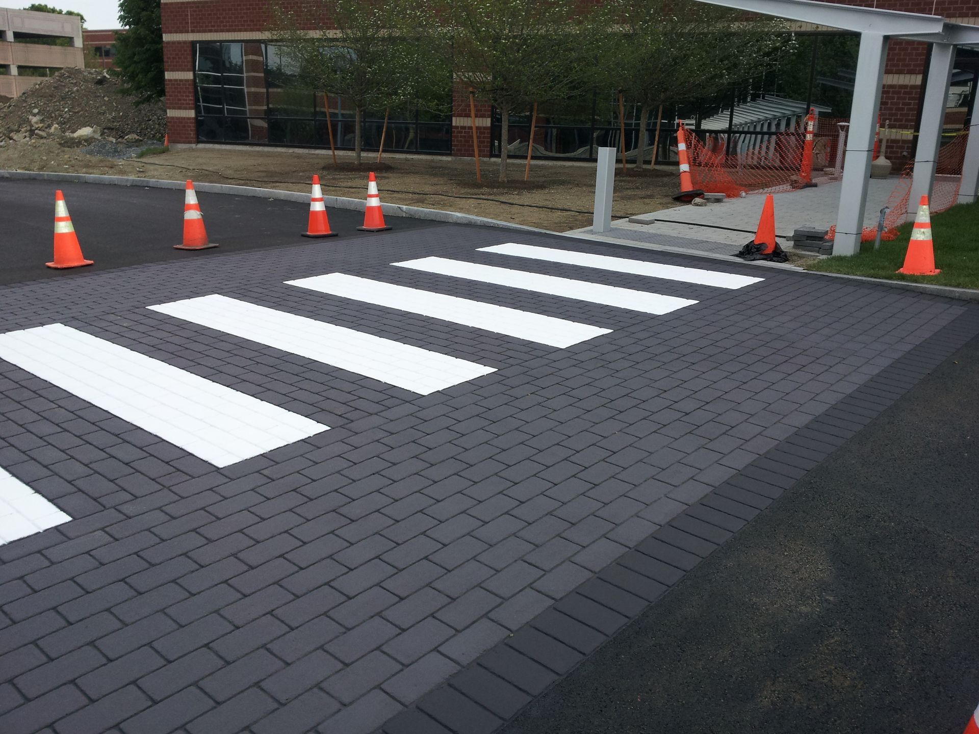 A brick walkway with a crosswalk painted on it