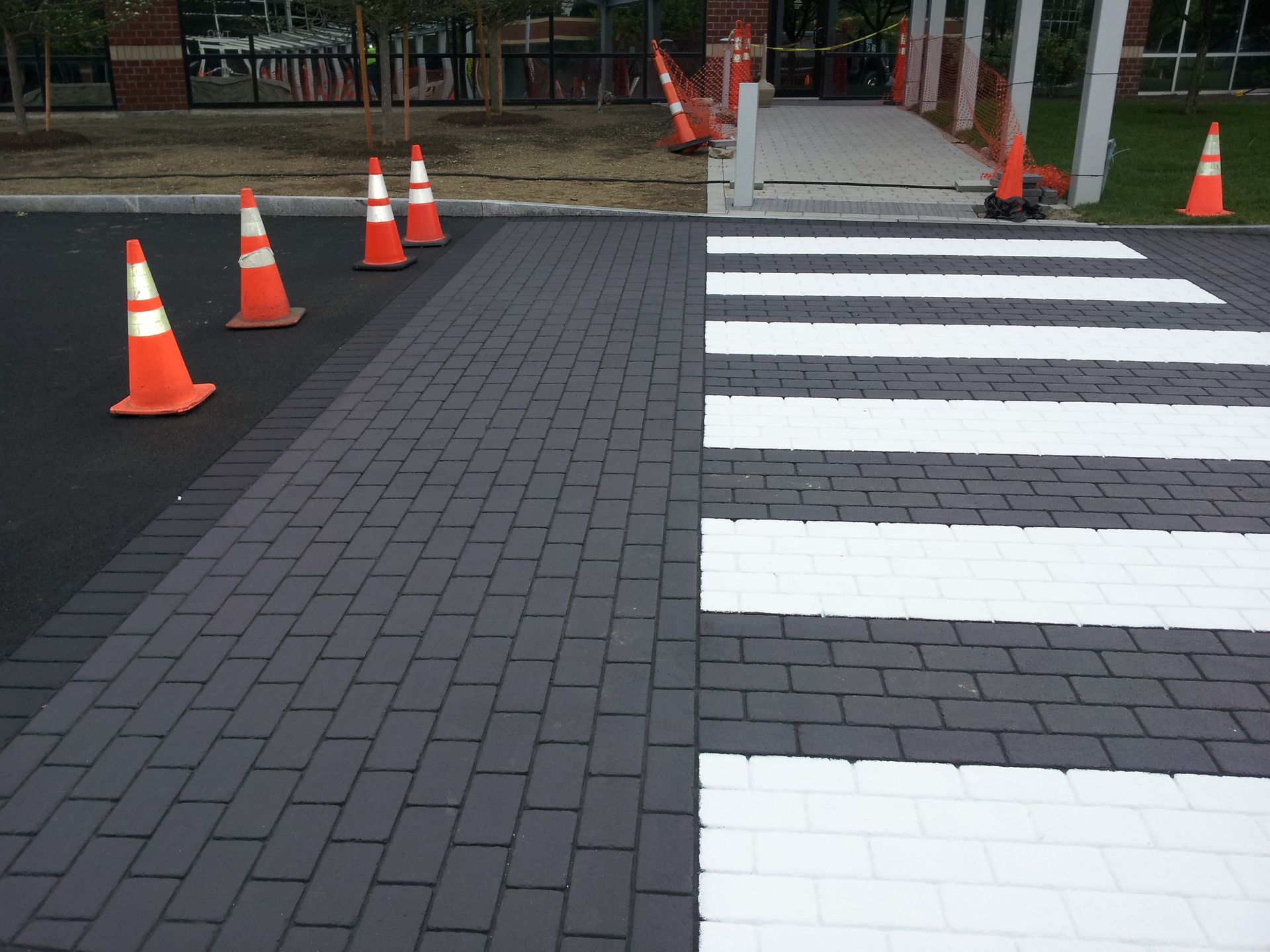 A brick walkway with a crosswalk painted on it