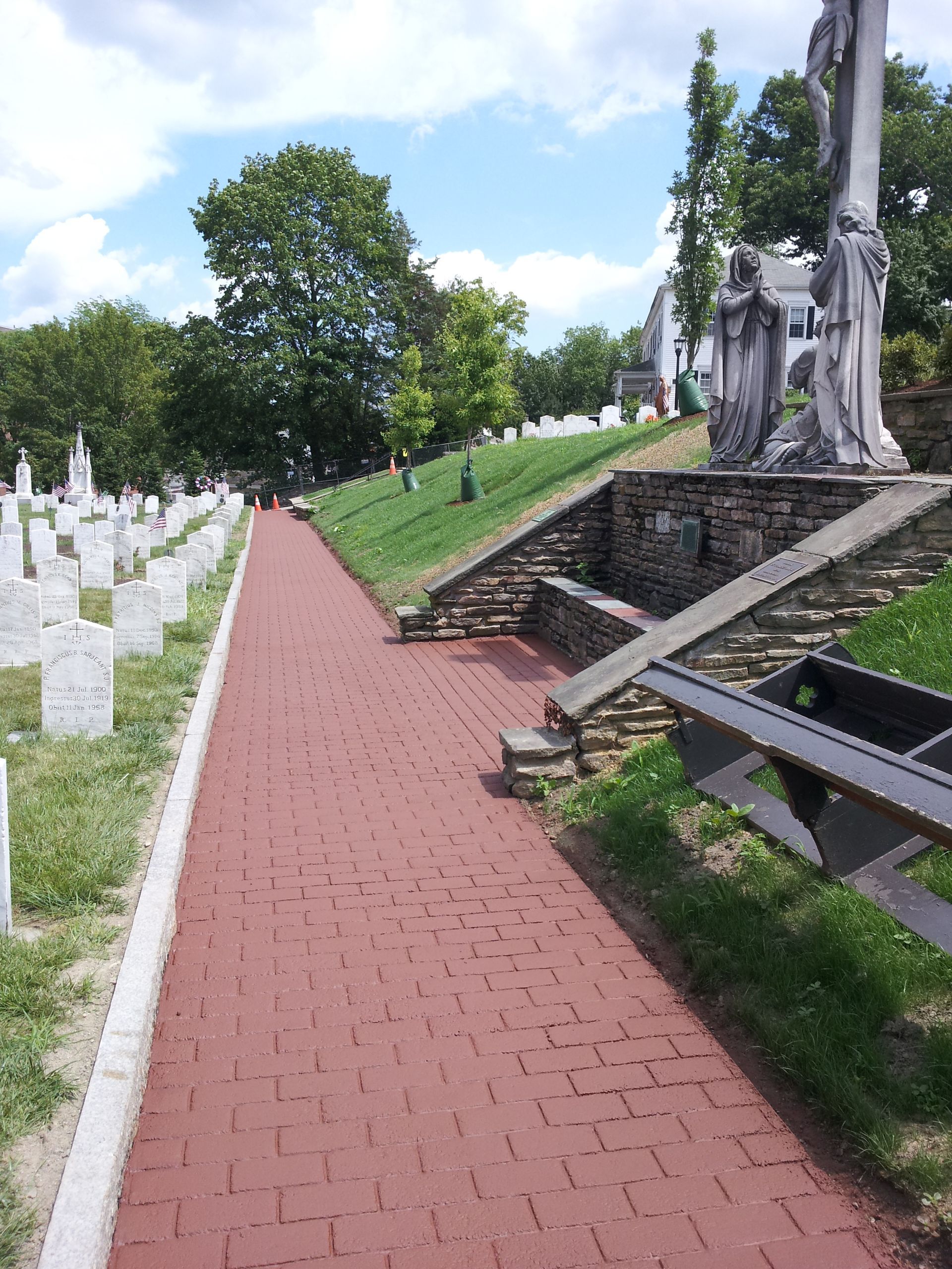 A brick walkway going through a cemetery