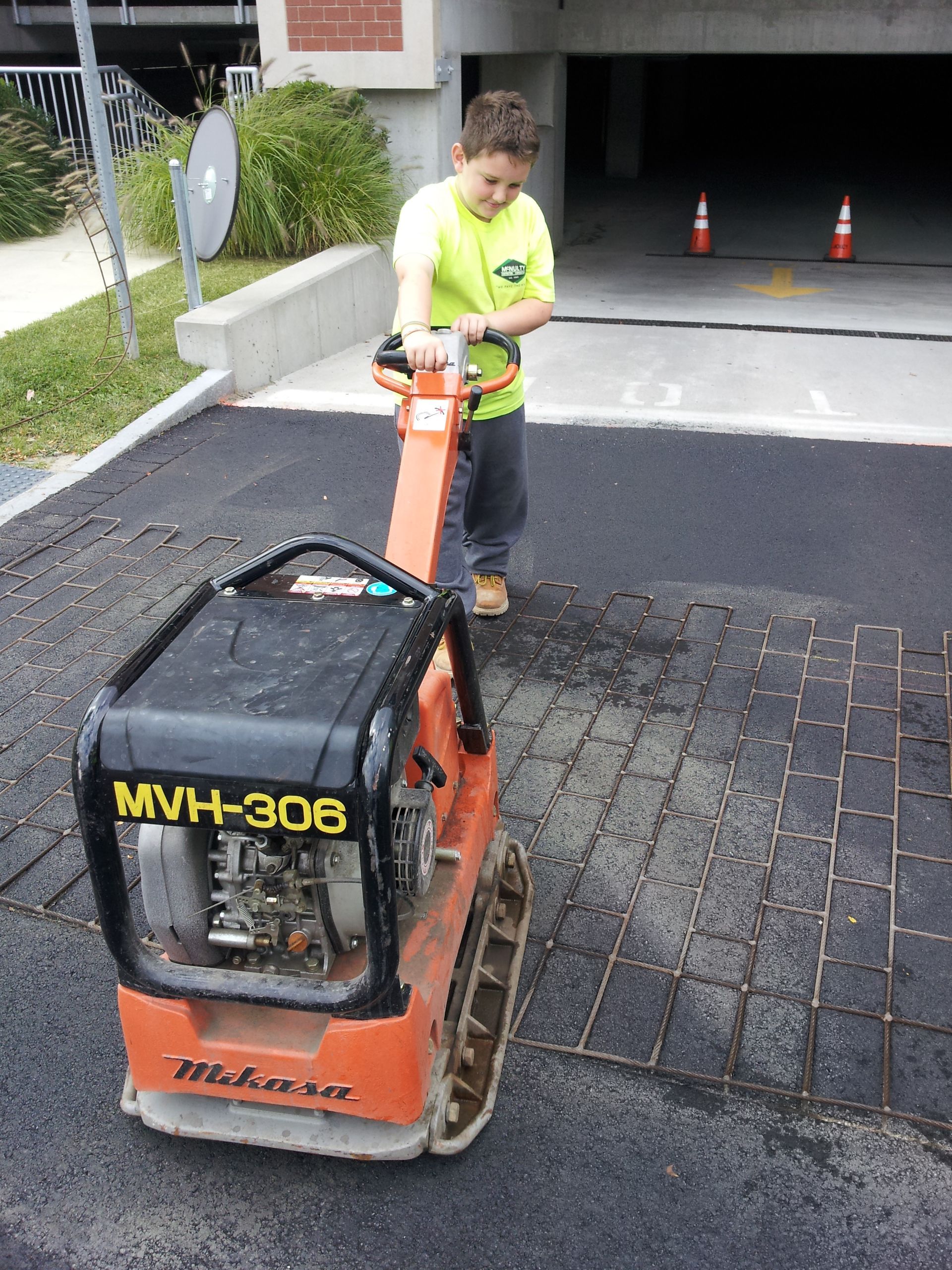 A man is pushing a machine that says mvh-306 on it
