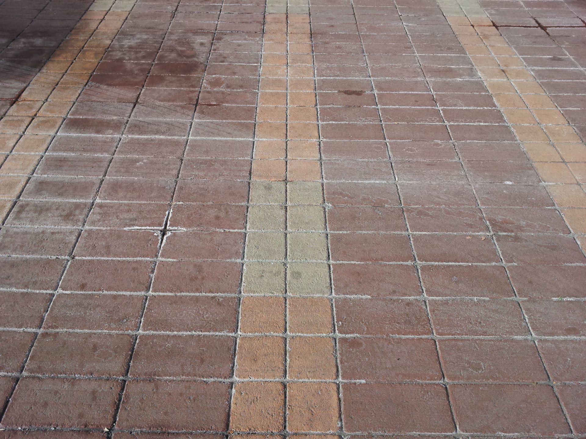 A brick walkway with a yellow line in the middle