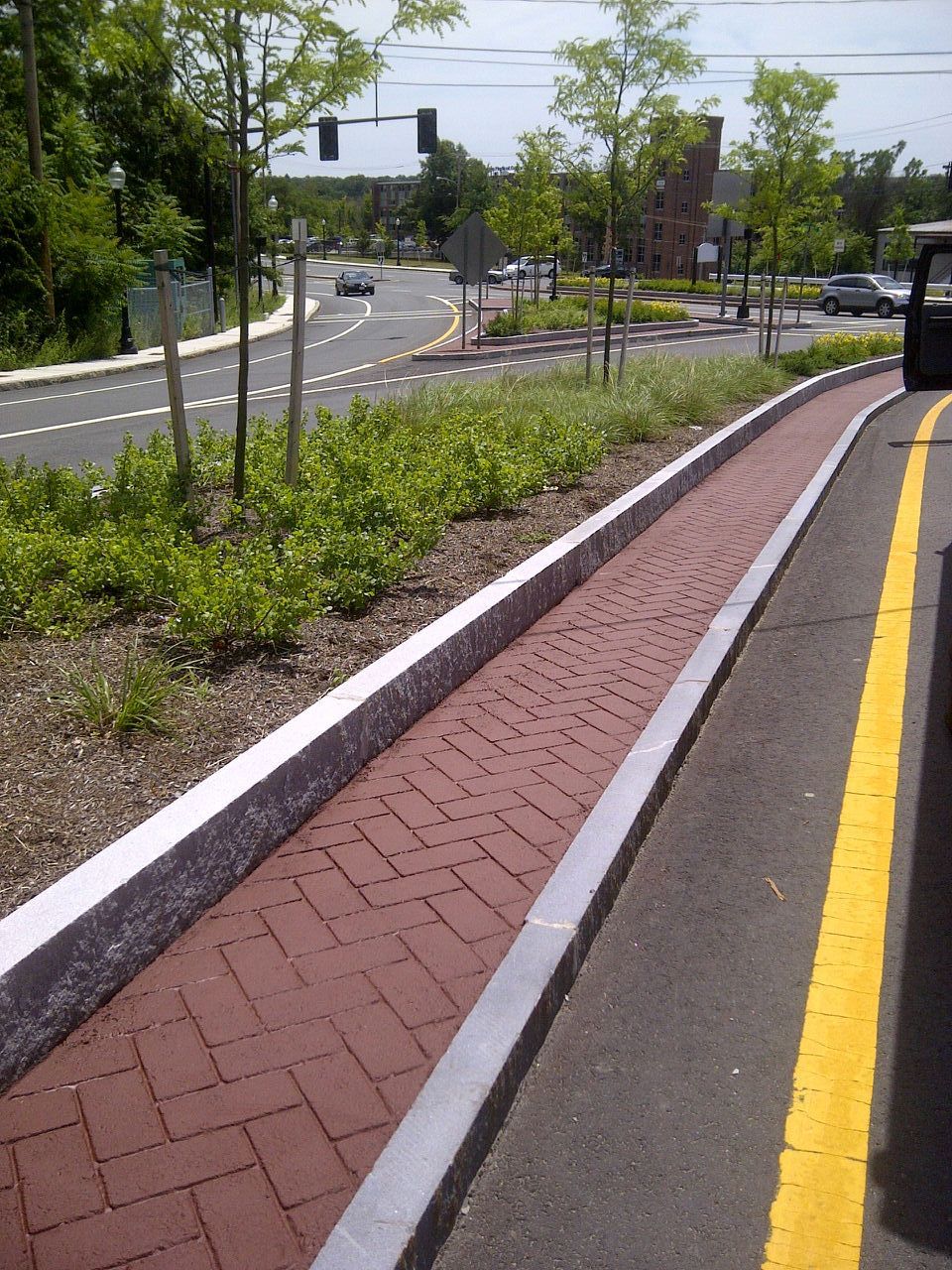 A brick walkway along the side of a road