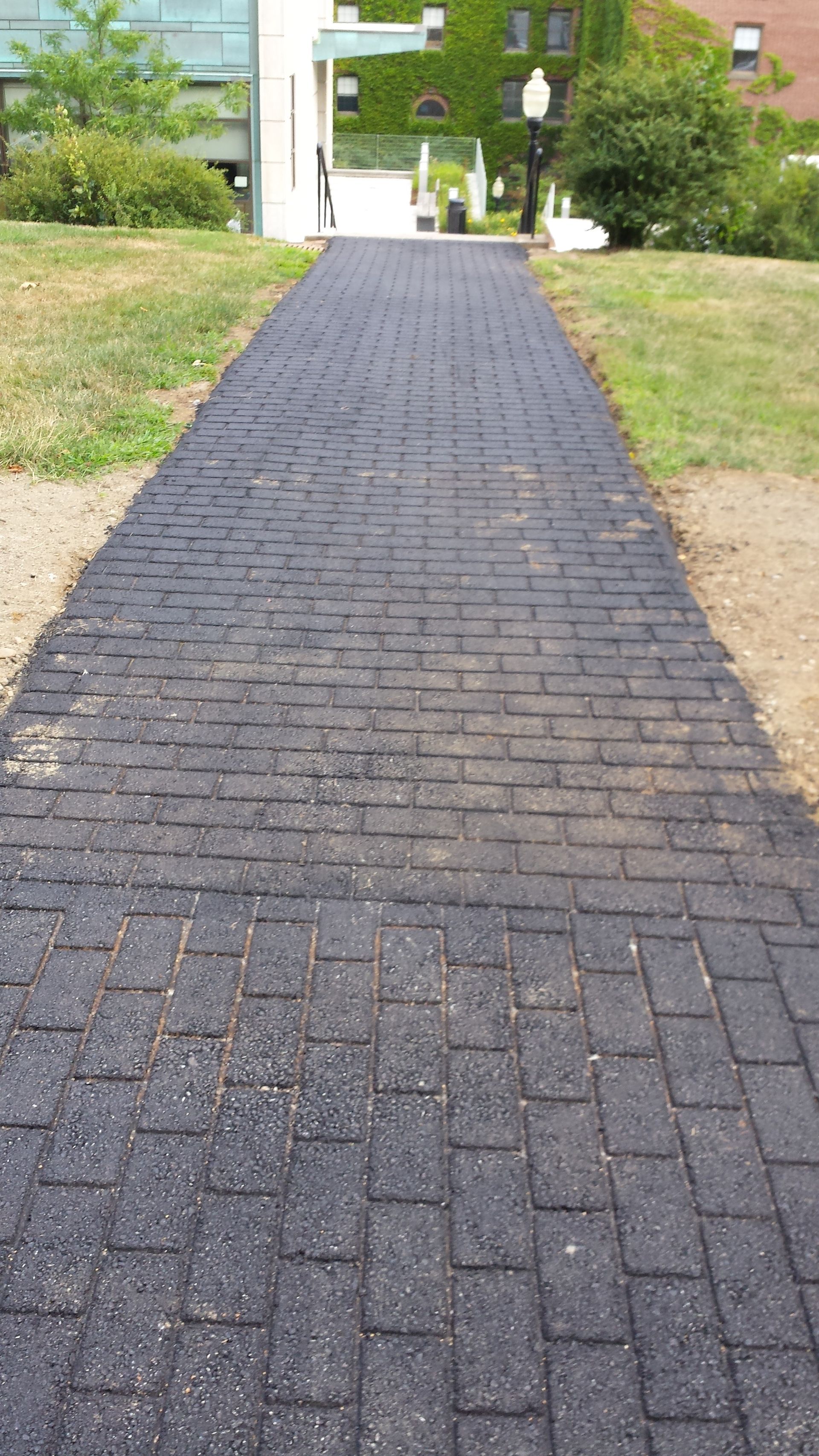 A black brick walkway leading to a building