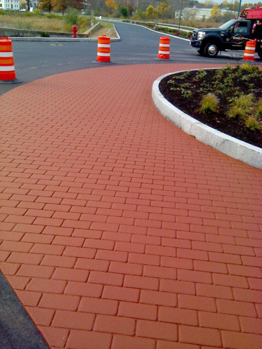 A truck is parked on the side of a brick road