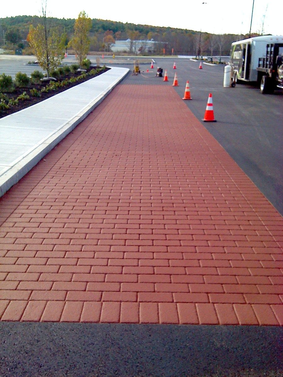 A red brick walkway with orange traffic cones on it