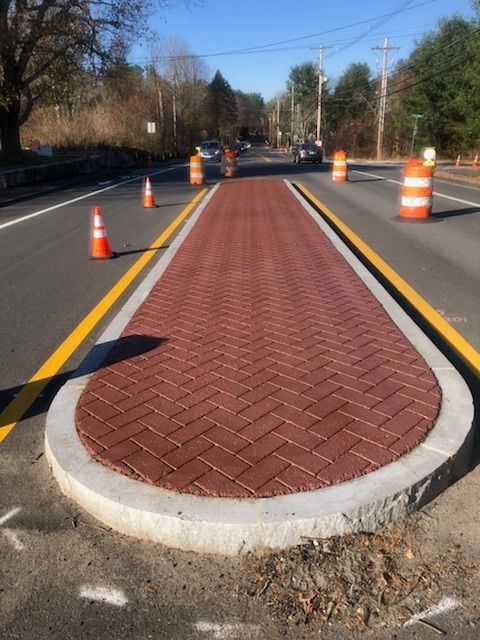 A brick walkway on the side of a road