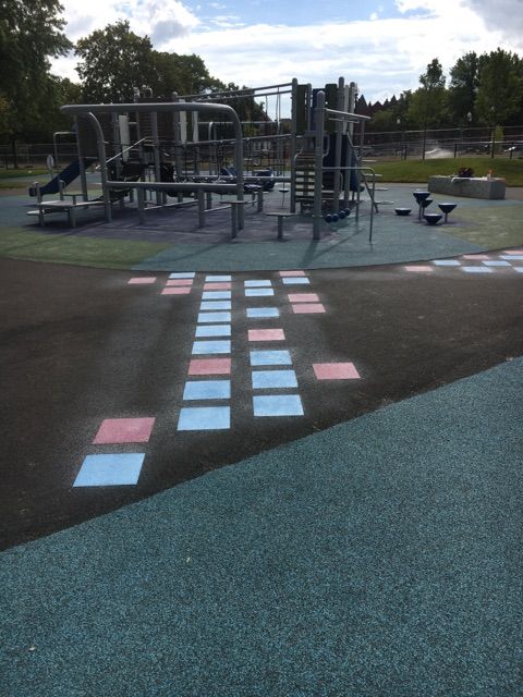 A playground with blue and pink squares painted on the ground