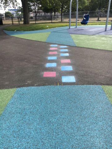 A playground with blue , pink and white squares painted on the ground