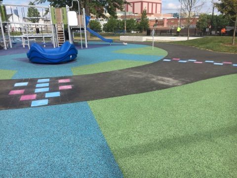 A playground with a blue rocker and a slide