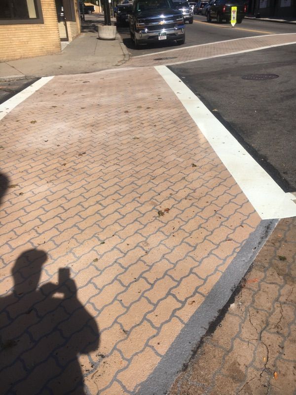 A person is taking a picture of a brick sidewalk