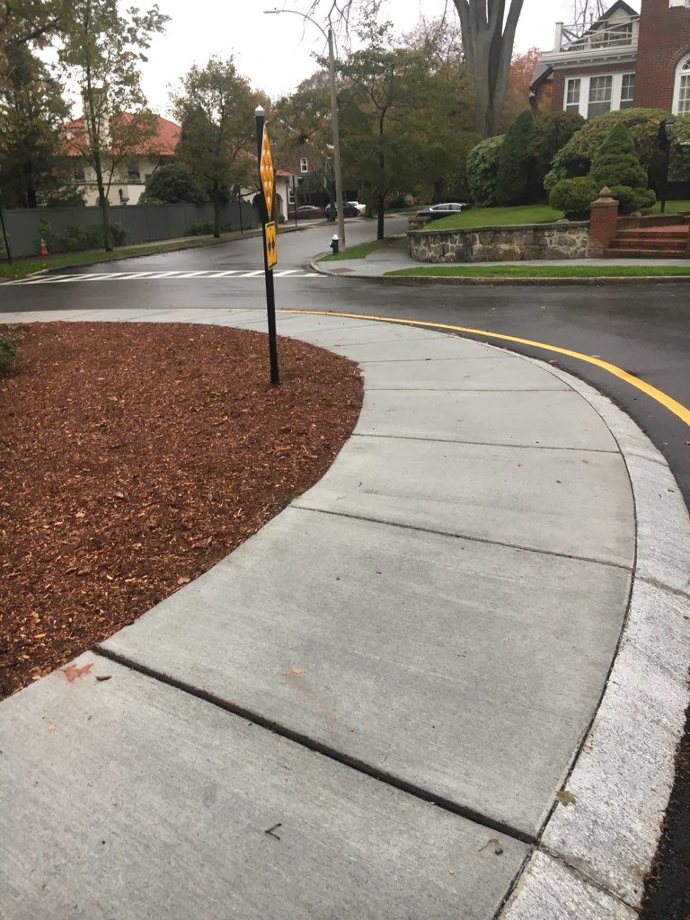 A concrete sidewalk with a yellow line on the side of it