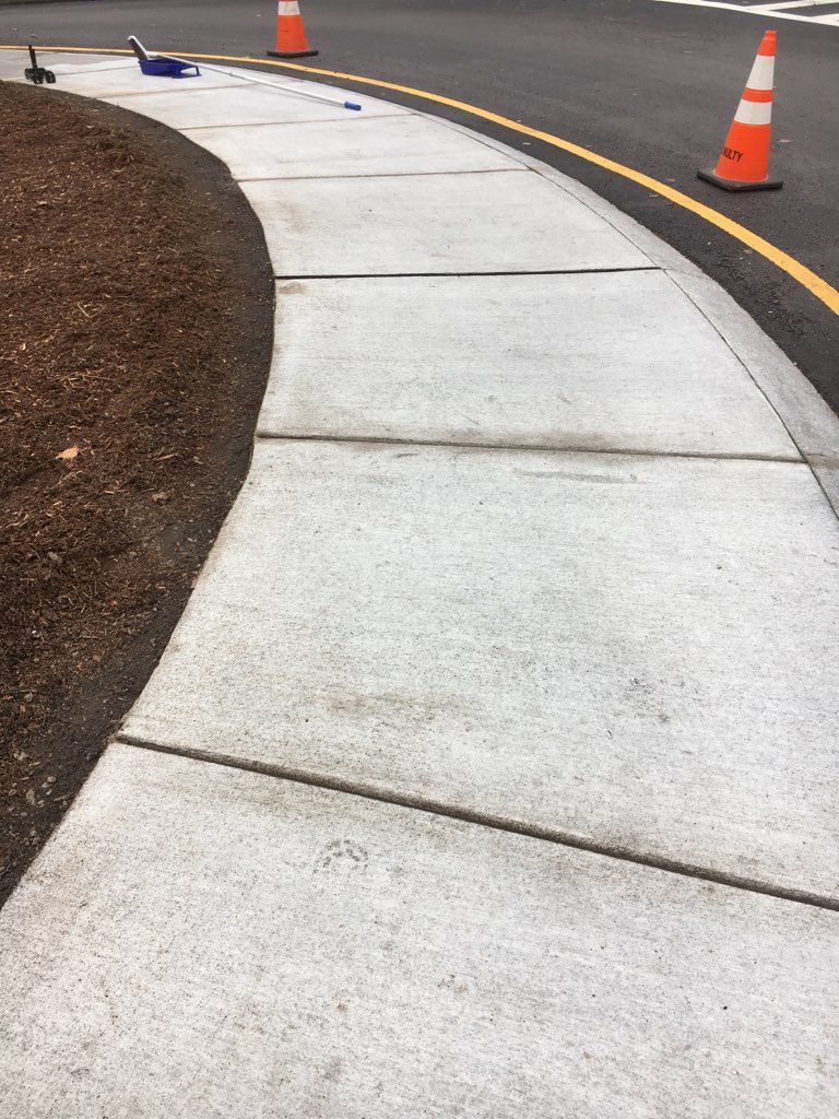 A concrete sidewalk is being built on the side of a road.