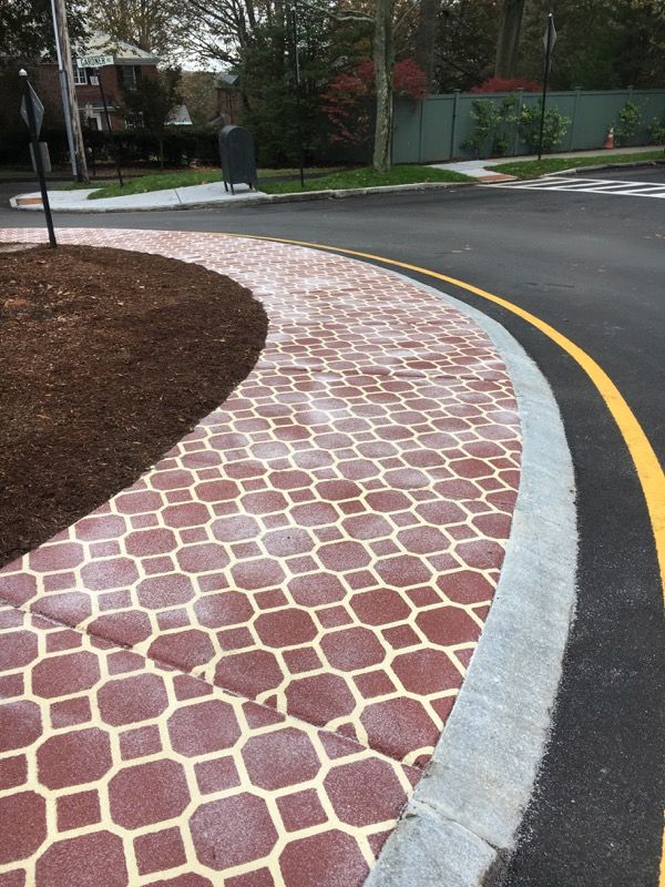 A road with a brick curb and a yellow line