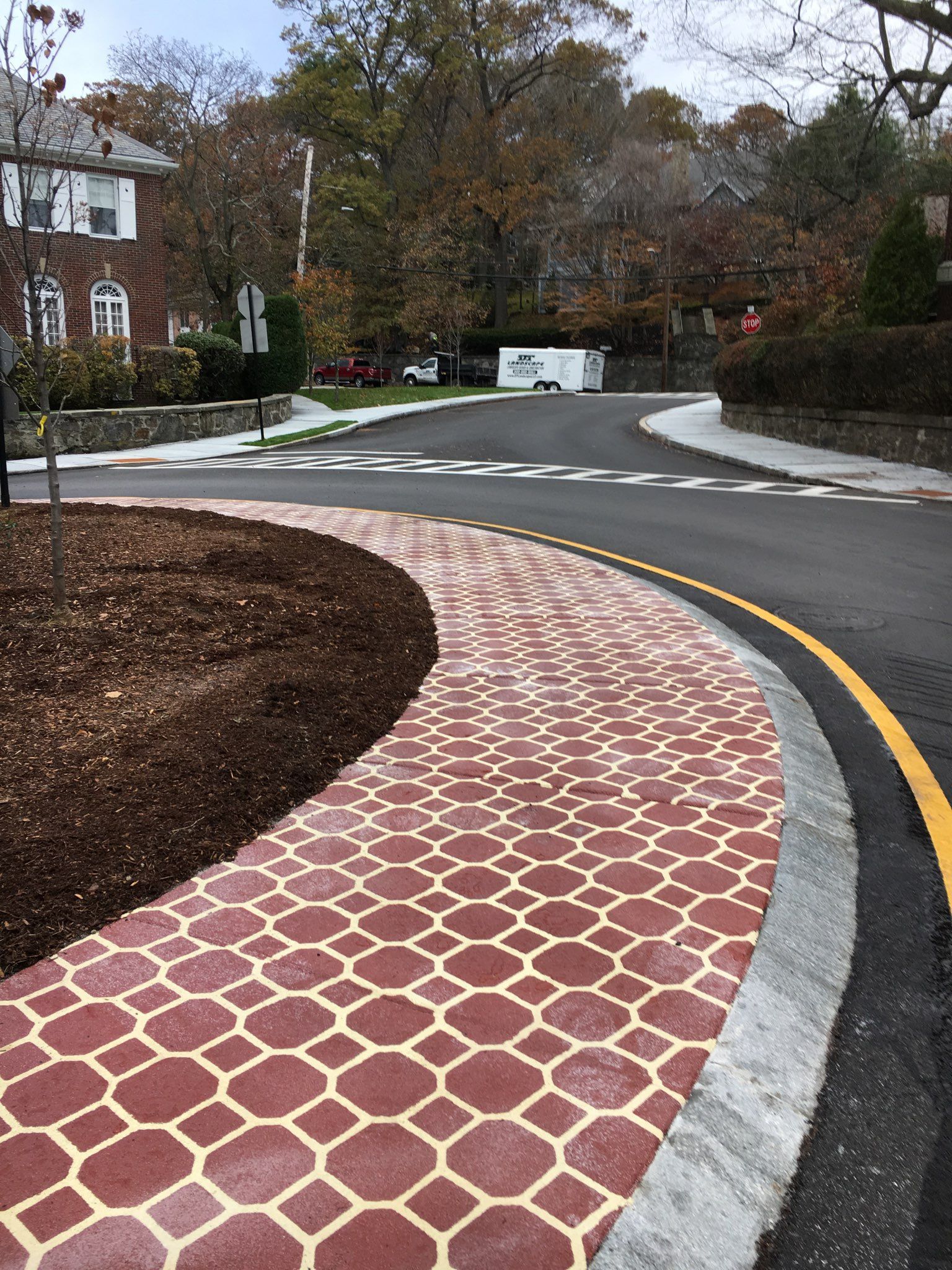 A street with a brick curb and a white truck in the background