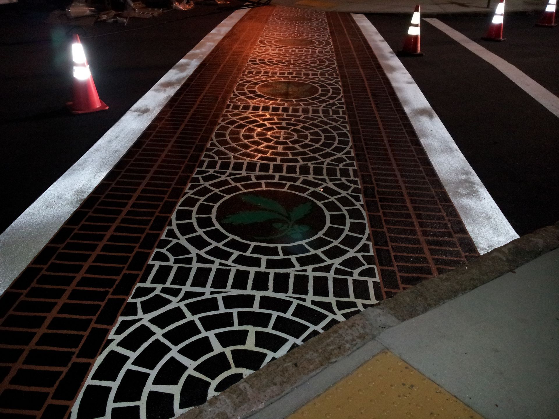 A brick walkway with a green bird painted on it
