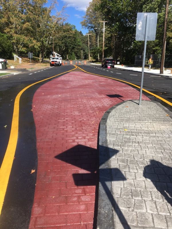 A street with a red brick walkway and a yellow line