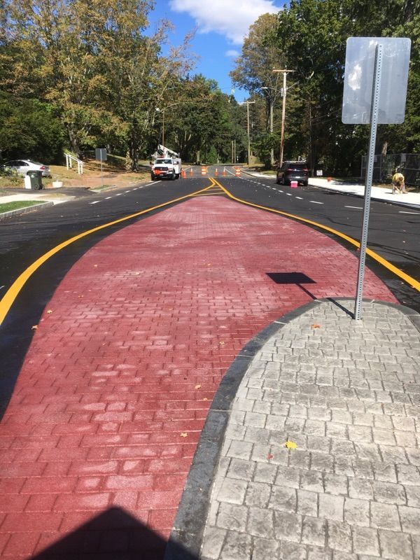 A street with a red curb and a white sign