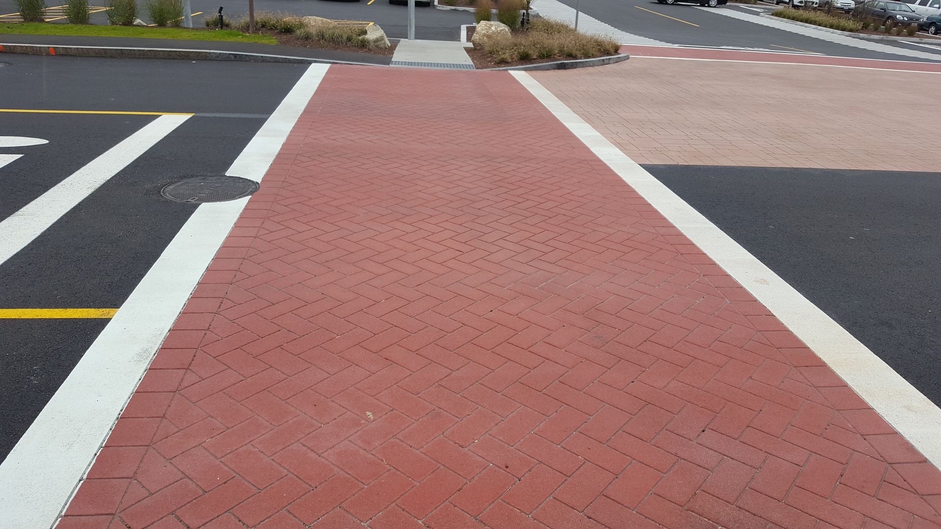 A red brick walkway with white lines on the road