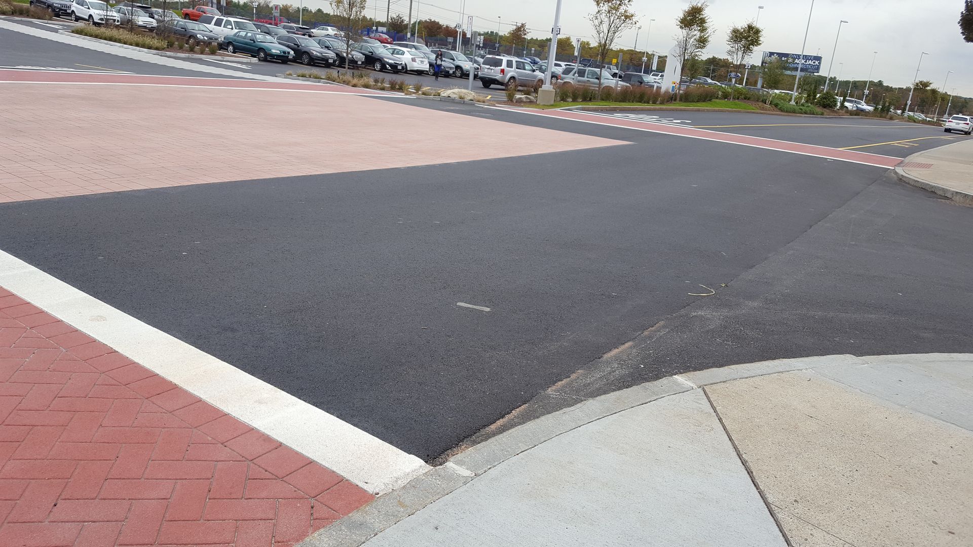A parking lot with cars parked on the side of the road