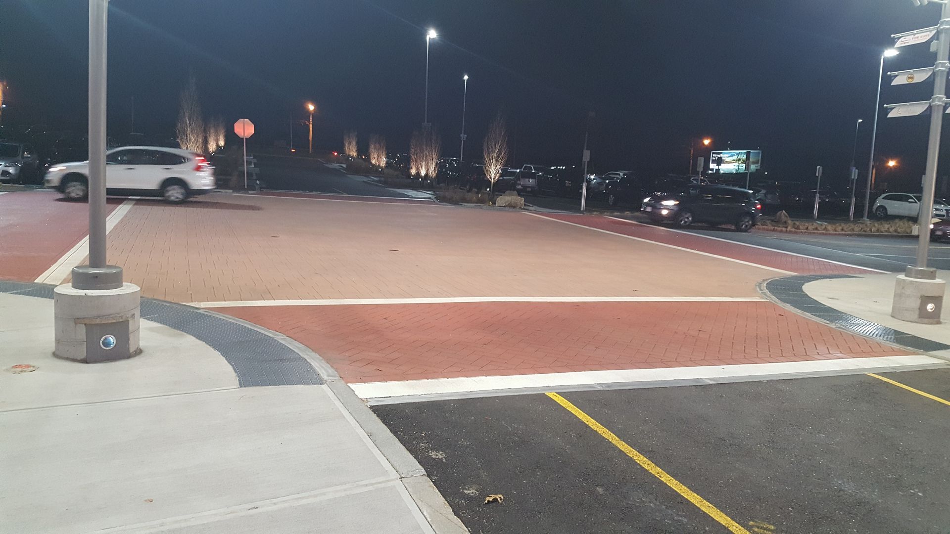 A car is parked in a parking lot at night.