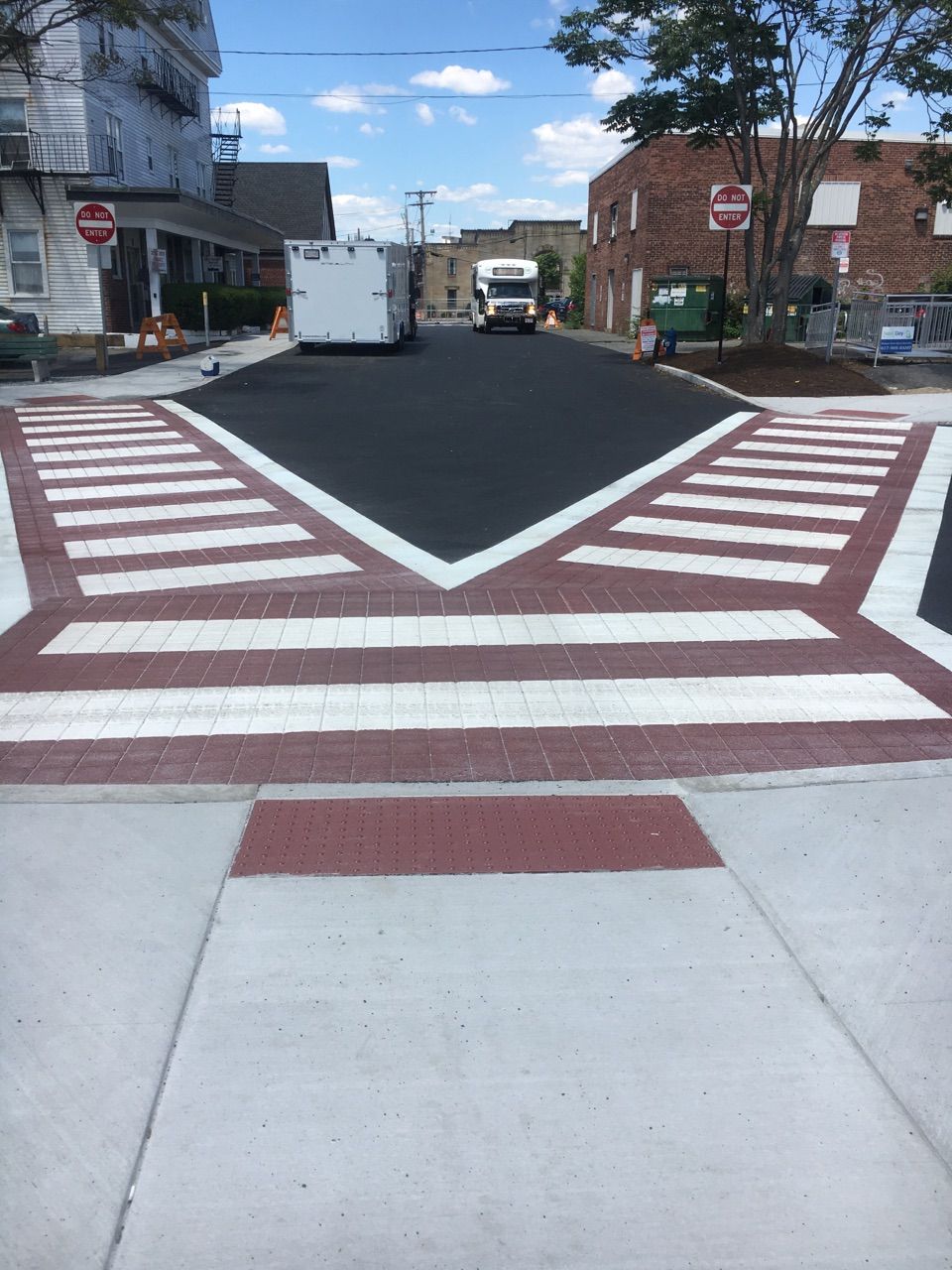 A red and white crosswalk with a stop sign in the background