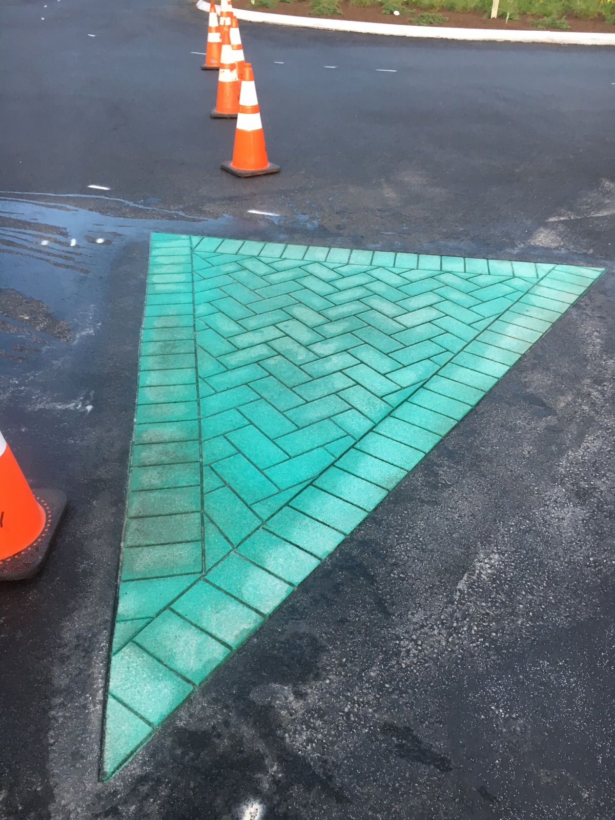 A green triangle is painted on the side of the road