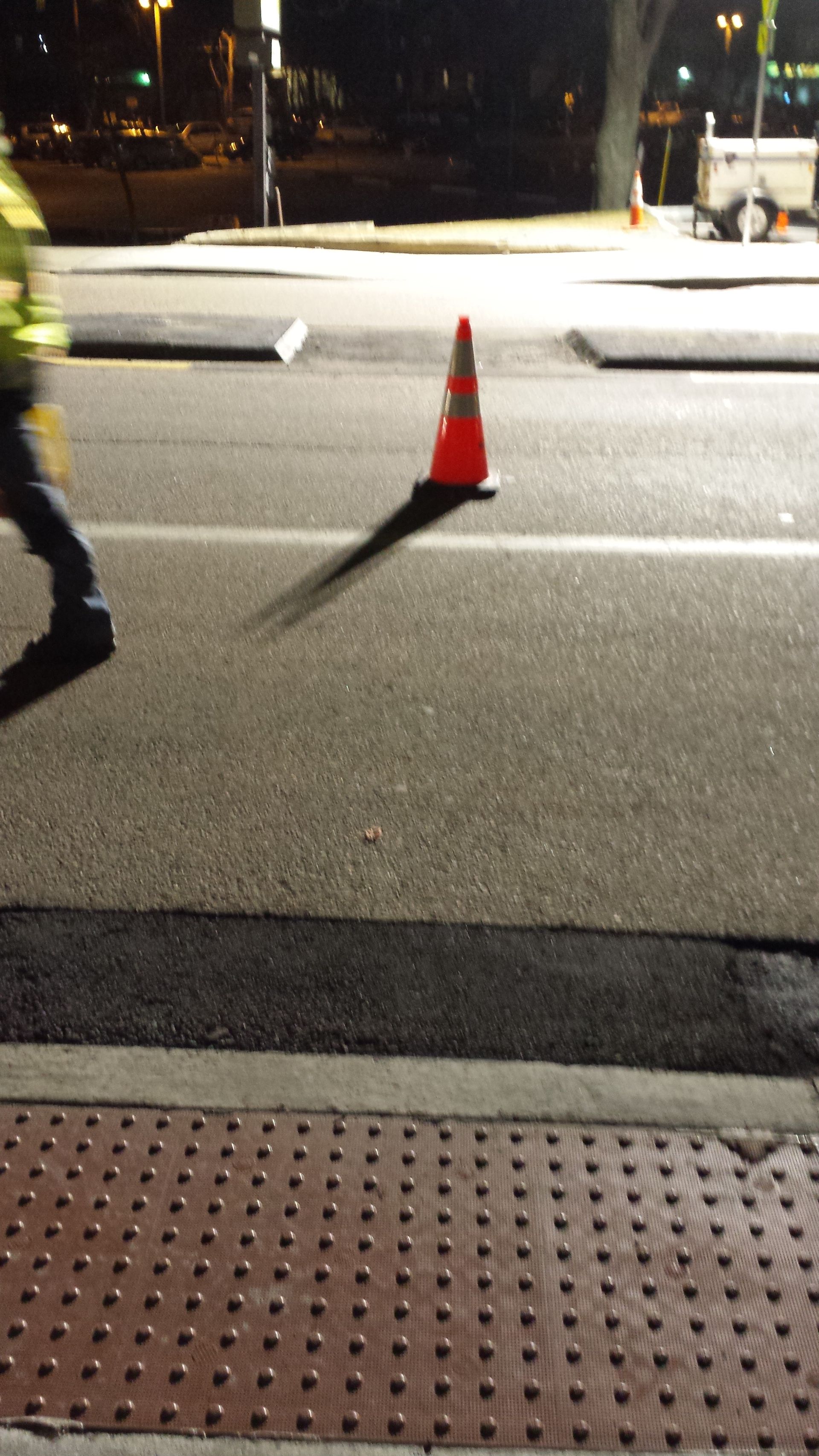 A person is walking across a street at night