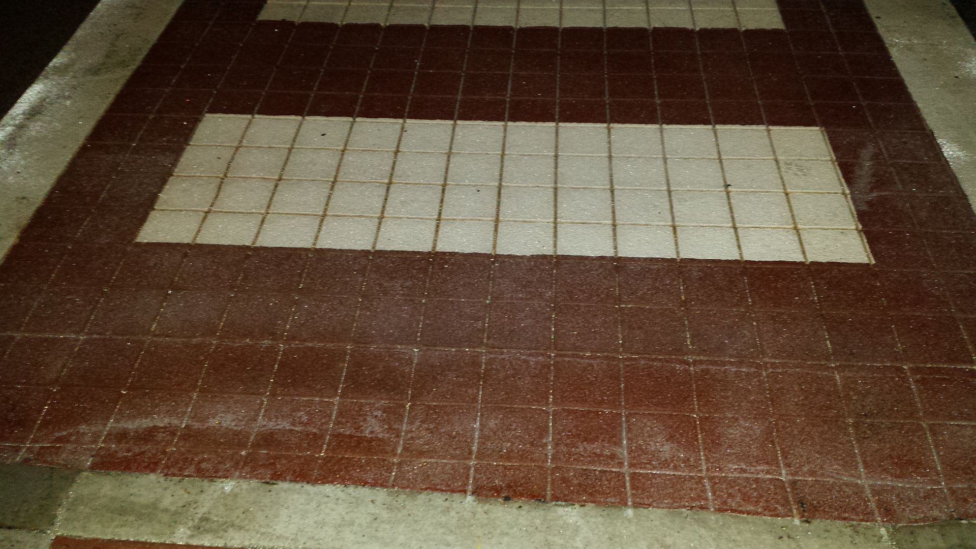 A red and white tile floor with a white square in the middle