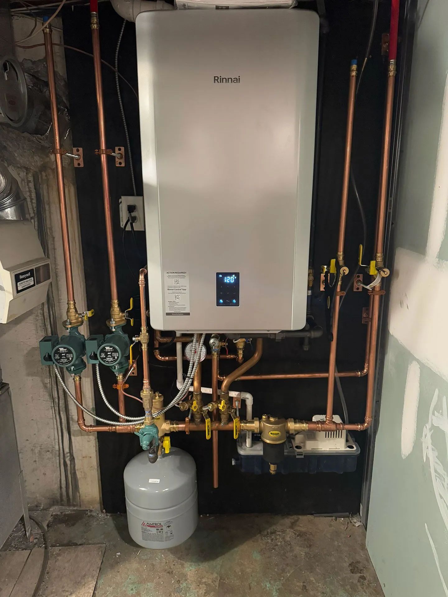Wall-mounted boiler in a utility room with copper pipes and a gray propane tank below.
