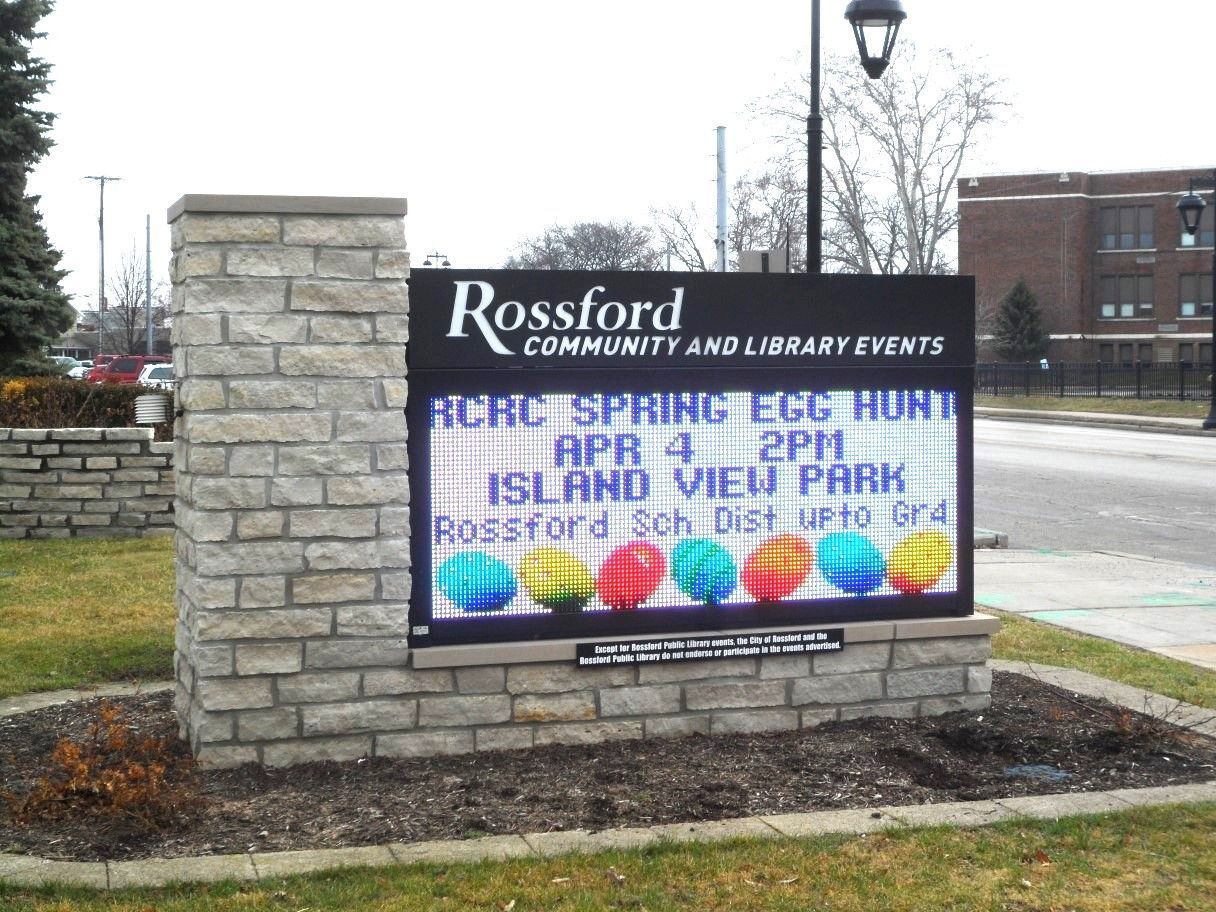 Sign for Rossford Community and Library events, advertising a spring egg hunt on April 4 at Island View Park.