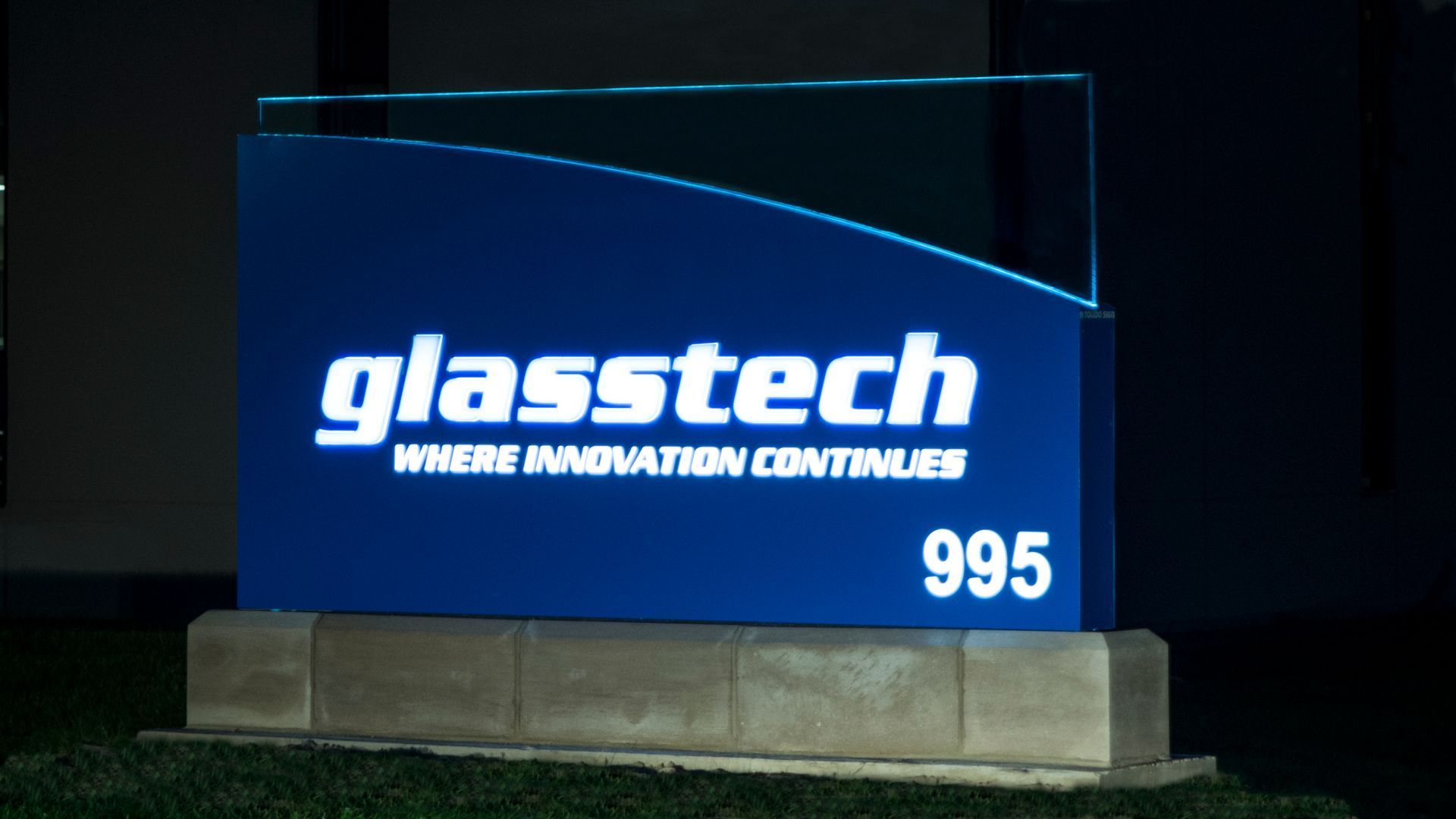 A blue sign that says glasstech where innovation continues