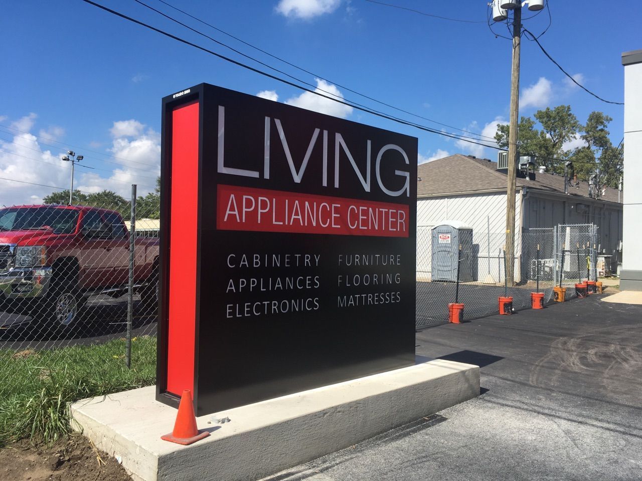 A living appliance center sign is in front of a building.