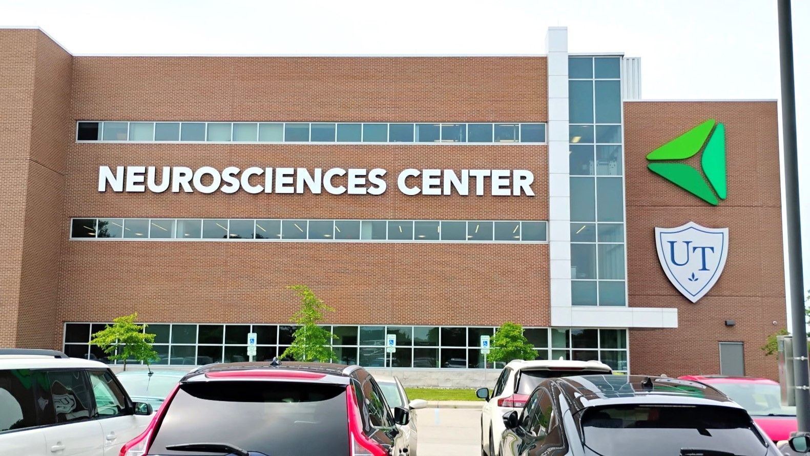 Neurosciences Center building with red brick facade and the UT logo.