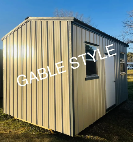Beige metal garden shed with white door and small window on grass, labeled “GABLE STYLE”