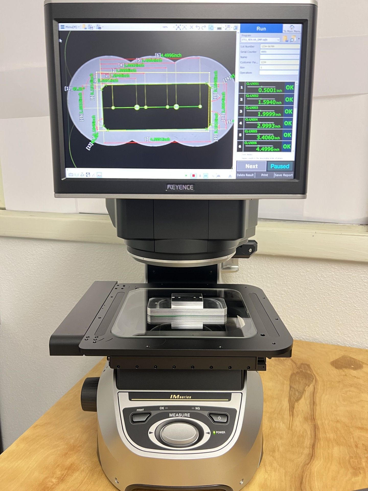 Optical comparator with a digital display showing a measured object.