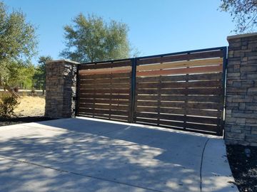 A black gate is open in front of a house