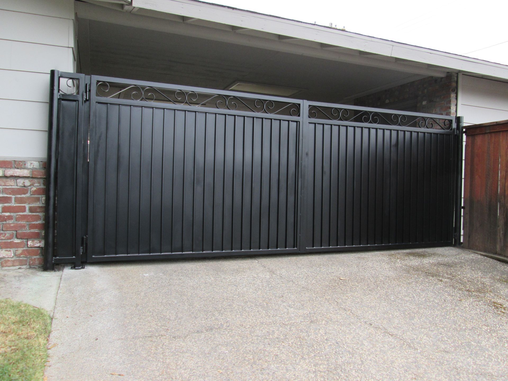 A black gate is sitting in front of a garage