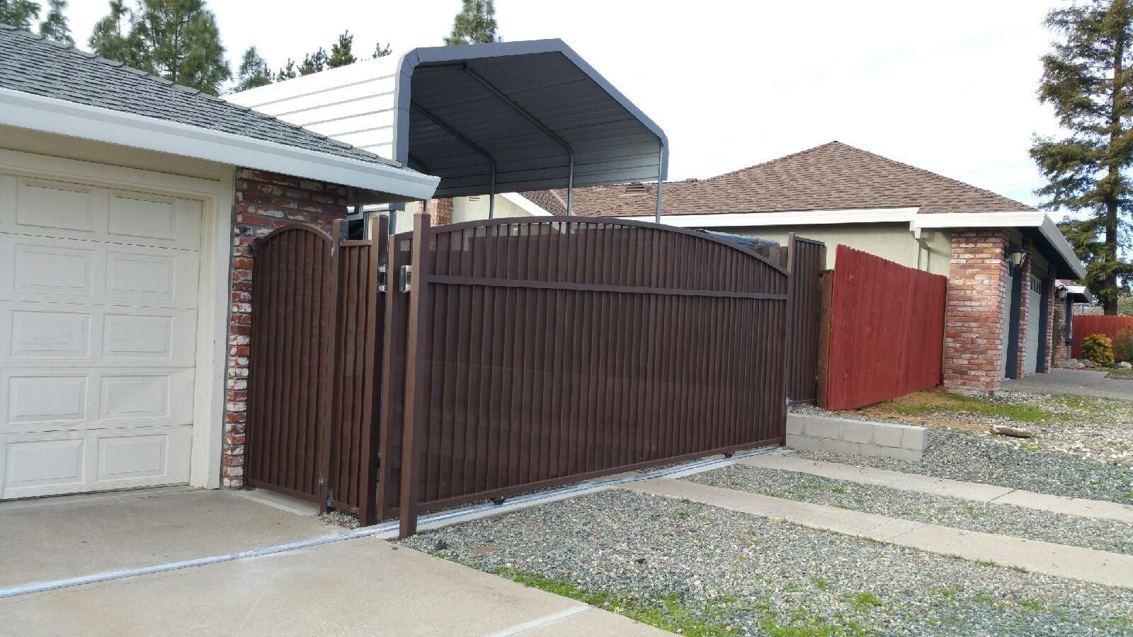 A house with a fence and a carport in front of it