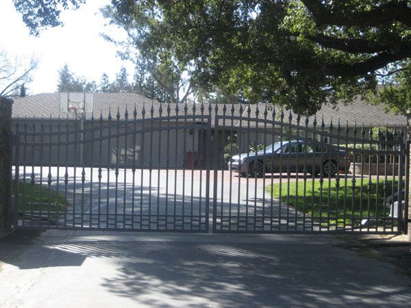 A car is parked in a driveway behind a gate