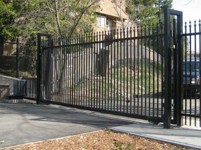 A black fence with a car parked in front of it