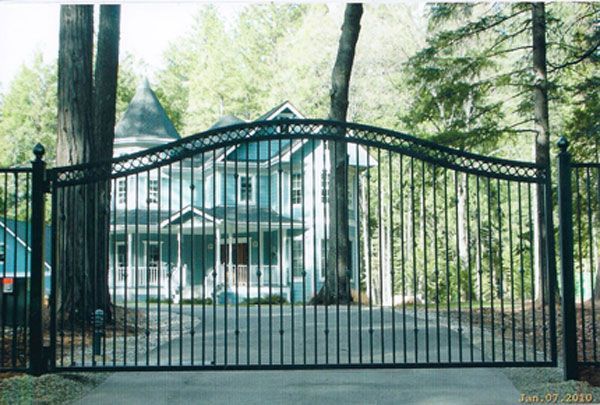 A large house is behind a wrought iron gate