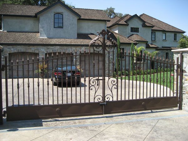 A car is parked in a driveway in front of a large house