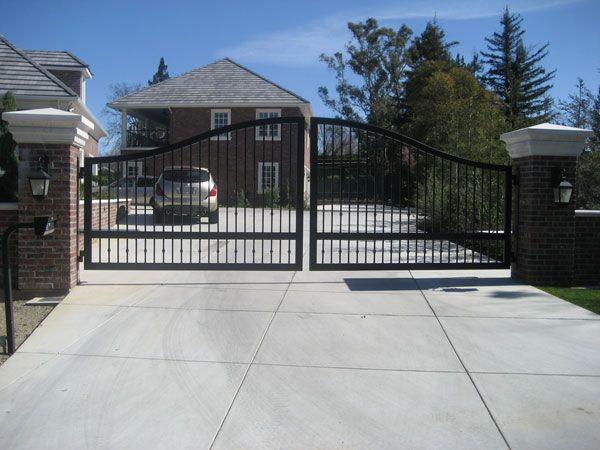 A car is parked in a driveway behind a gate