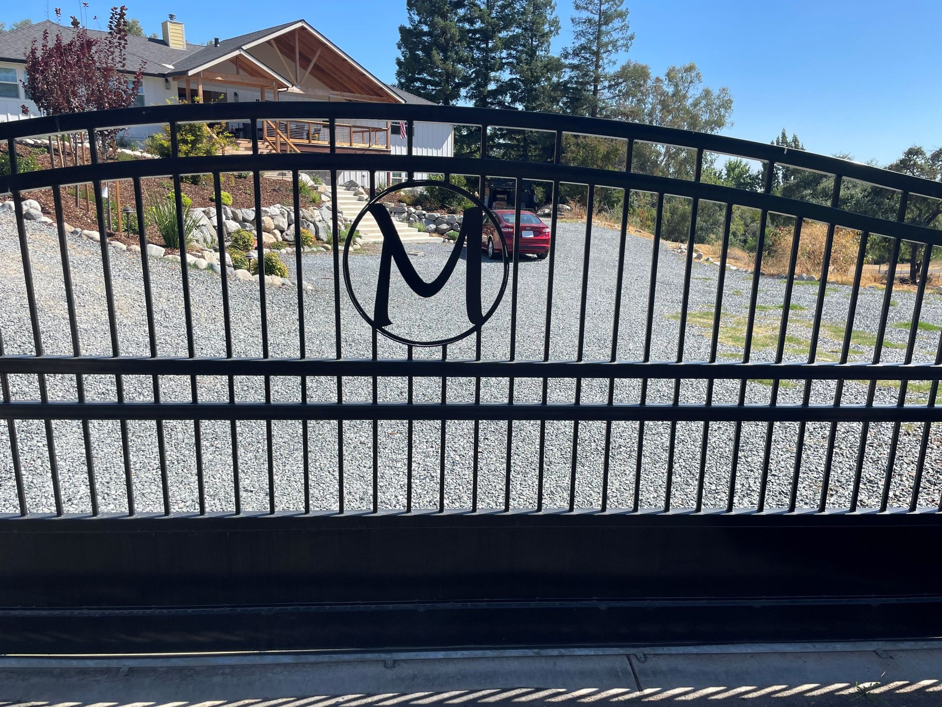 A black gate with the letter m on it