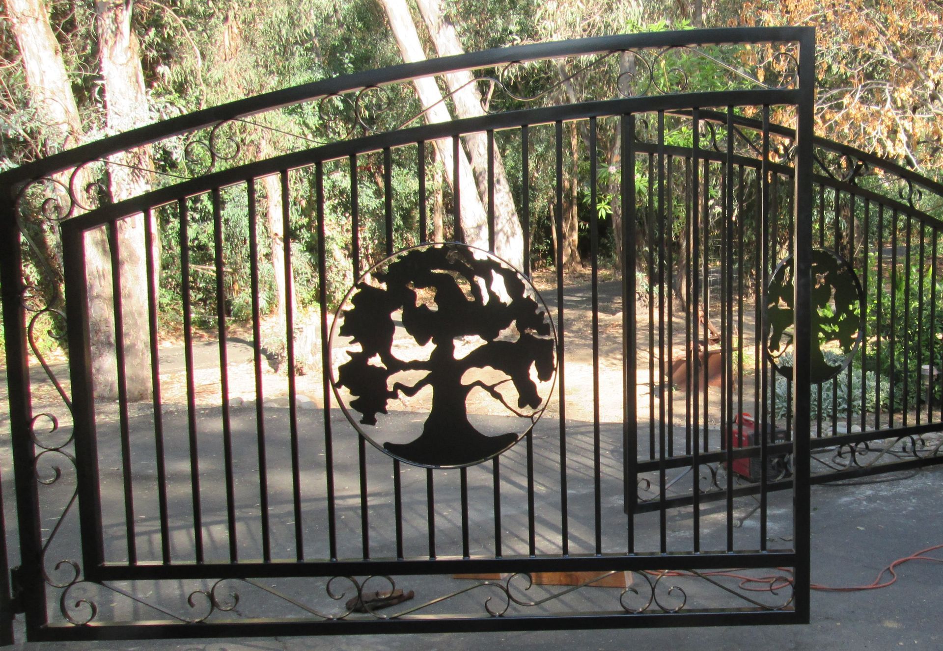 A wrought iron gate with a tree on it