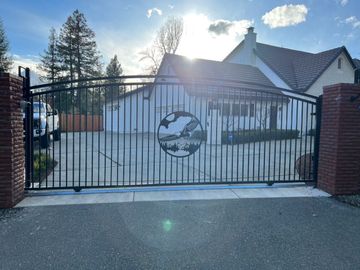 A black gate is open in front of a house